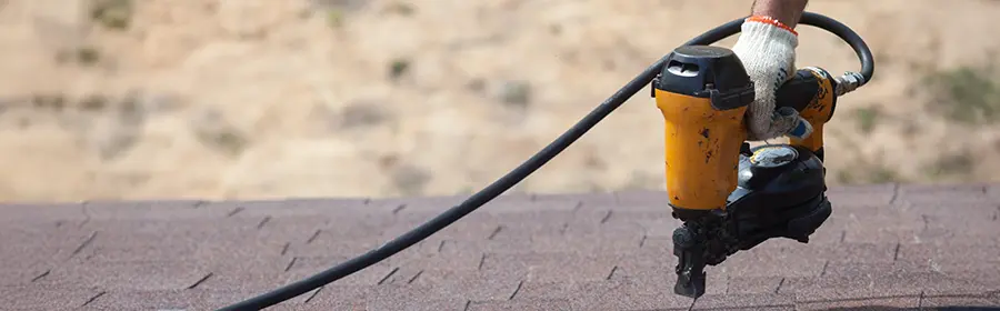 Roofer using a nail gun